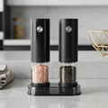 Black pepper and salt grinders on a kitchen counter with a blurred background